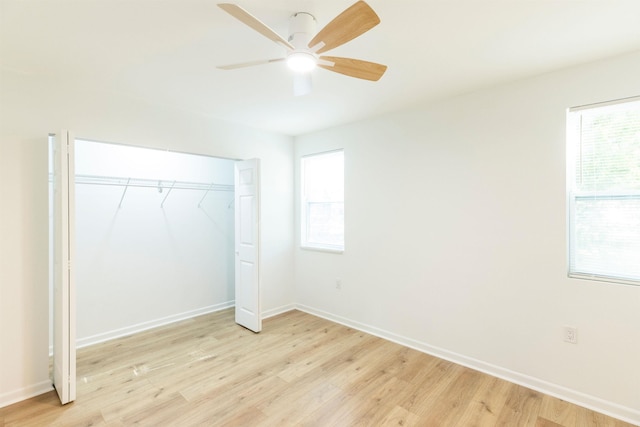 unfurnished bedroom featuring multiple windows, a closet, ceiling fan, and light wood-type flooring