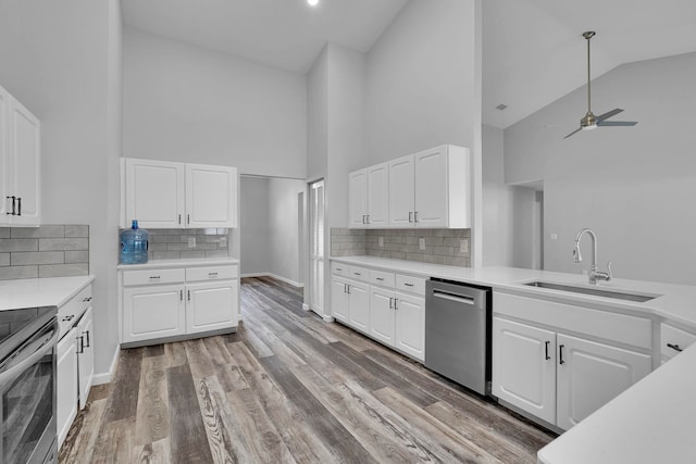 61 Brownstone Ln, Palm Coast, FL 32137 - kitchen with stainless steel appliances, high vaulted ceiling, ceiling fan, light countertops, and white cabinets