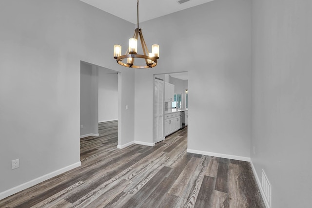 61 Brownstone Ln, Palm Coast, FL 32137 - empty room with a chandelier, dark wood finished floors, and a towering ceiling