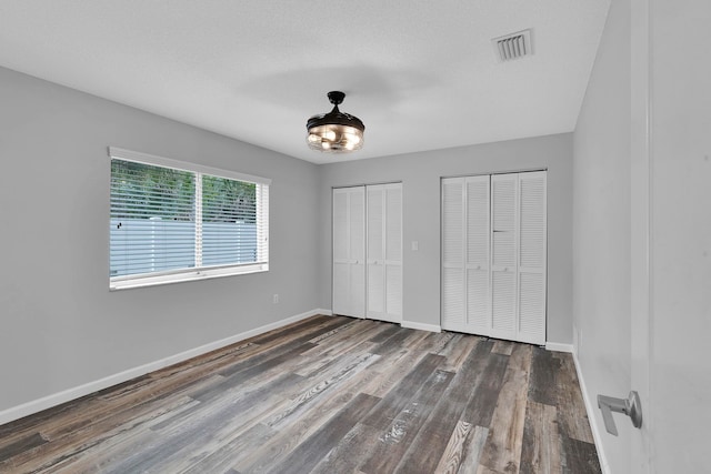 61 Brownstone Ln, Palm Coast, FL 32137 - unfurnished bedroom featuring two closets and wood finished floors