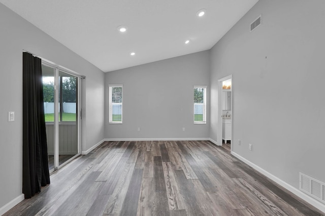 61 Brownstone Ln, Palm Coast, FL 32137 - spare room featuring healthy amount of natural light, dark wood finished floors, lofted ceiling, and recessed lighting