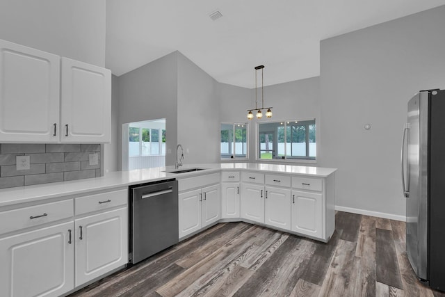 61 Brownstone Ln, Palm Coast, FL 32137 - kitchen featuring stainless steel appliances, a high ceiling, a chandelier, white cabinets, and dark wood finished floors