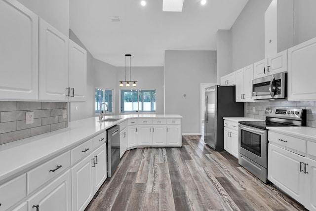 61 Brownstone Ln, Palm Coast, FL 32137 - kitchen with stainless steel appliances, a peninsula, white cabinets, backsplash, and light countertops