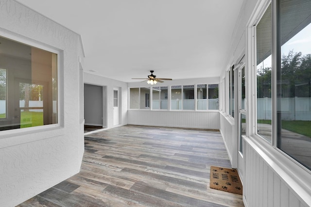 61 Brownstone Ln, Palm Coast, FL 32137 - unfurnished sunroom featuring wood finished floors, ceiling fan, and a textured wall