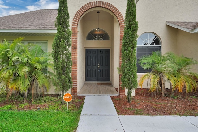 61 Brownstone Ln, Palm Coast, FL 32137 - property entrance with stucco siding and roof with shingles