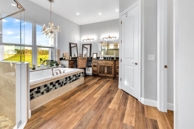 bathroom featuring hardwood / wood-style floors, vanity, a tub, and a chandelier