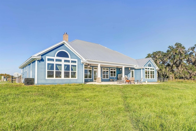 back of property with a patio area and a yard