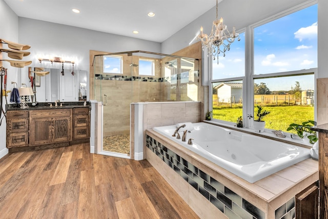 bathroom featuring hardwood / wood-style floors, independent shower and bath, a wealth of natural light, and a chandelier