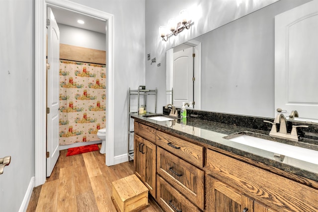 full bathroom featuring vanity, toilet, wood-type flooring, and shower / tub combo with curtain