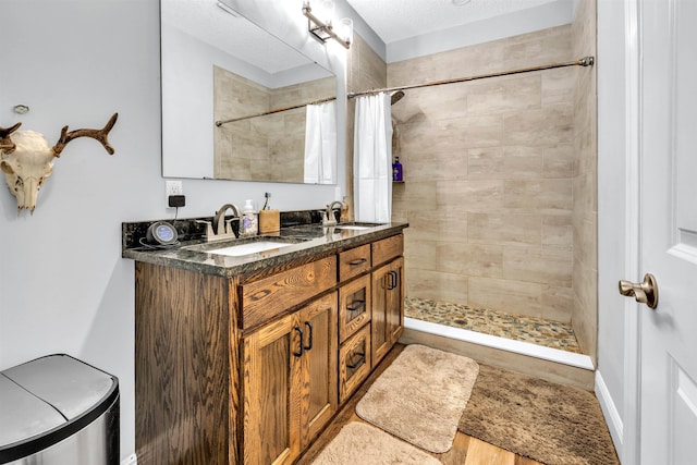 bathroom featuring a shower with curtain, hardwood / wood-style floors, vanity, and a textured ceiling