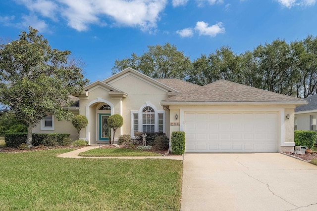 single story home with a garage, driveway, a front lawn, and stucco siding