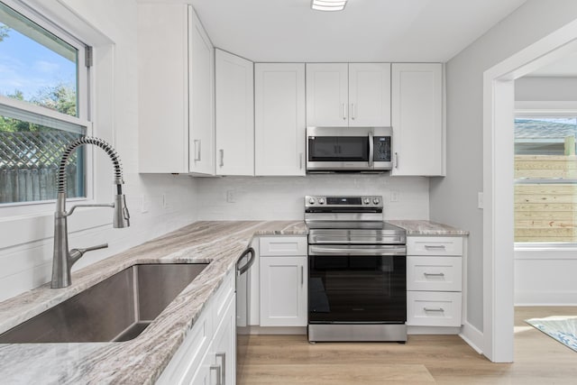 112 2nd St, Saint Augustine, FL 32080 - kitchen with appliances with stainless steel finishes, a sink, and white cabinetry