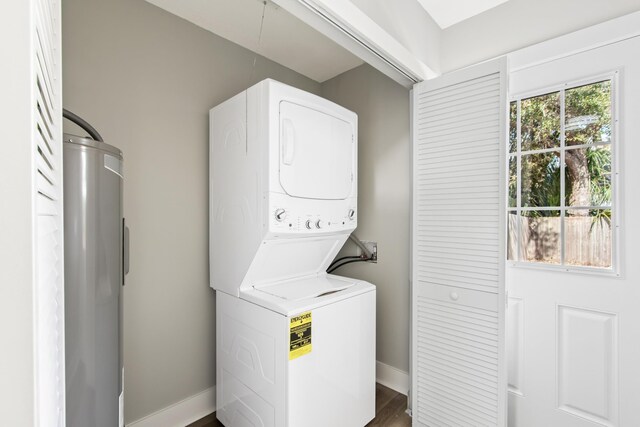 112 2nd St, Saint Augustine, FL 32080 - laundry room featuring stacked washer / drying machine, water heater, baseboards, and attic access