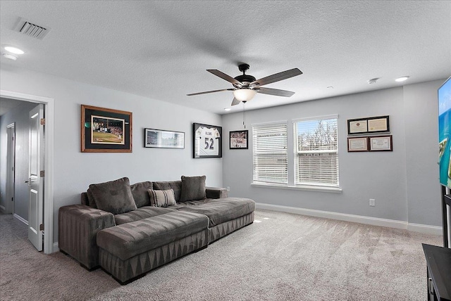 carpeted living area featuring visible vents, ceiling fan, a textured ceiling, and baseboards