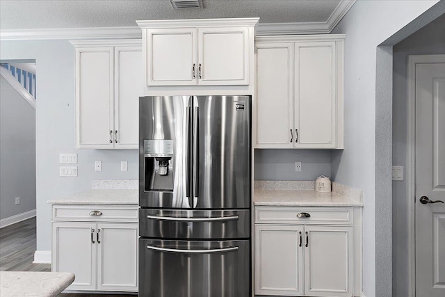 kitchen featuring white cabinets, baseboards, stainless steel refrigerator with ice dispenser, and ornamental molding