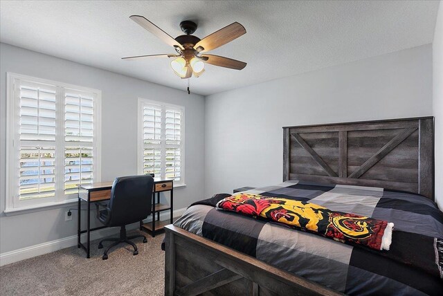 carpeted bedroom with multiple windows, a textured ceiling, baseboards, and ceiling fan