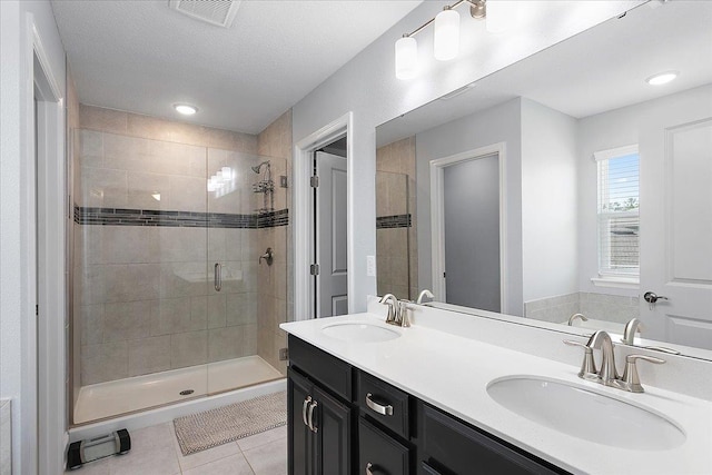 bathroom featuring a sink, visible vents, a stall shower, and tile patterned floors