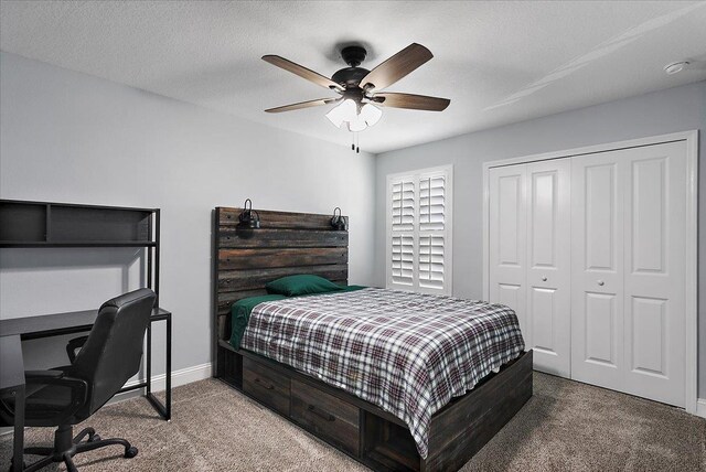 bedroom with a textured ceiling, a closet, carpet floors, baseboards, and ceiling fan