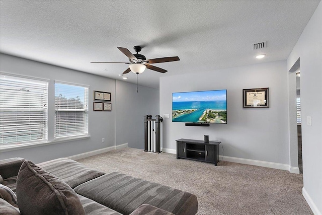 carpeted living room with visible vents, ceiling fan, a textured ceiling, and baseboards