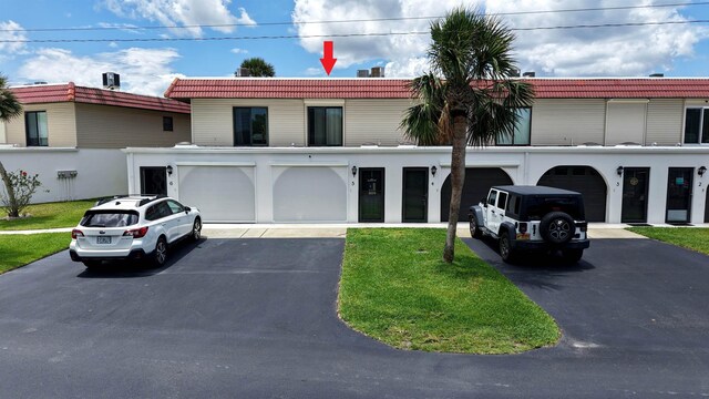 5 N Ocean Palm Villas Unit 5, Flagler Beach, FL 32136 - view of front of home with driveway, a tiled roof, an attached garage, and a front yard