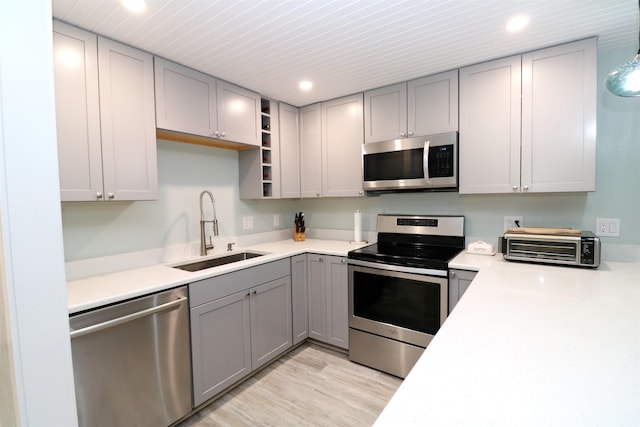 5 N Ocean Palm Villas Unit 5, Flagler Beach, FL 32136 - kitchen with appliances with stainless steel finishes, a sink, gray cabinets, recessed lighting, and light wood-style flooring