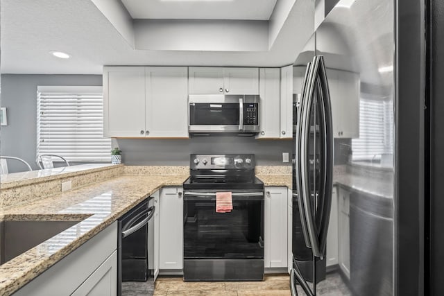 850 A1A Beach Blvd Unit 3, Saint Augustine Beach, FL 32080 - kitchen with appliances with stainless steel finishes, white cabinets, a raised ceiling, light stone counters, and recessed lighting