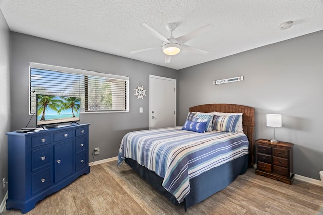 bedroom featuring ceiling fan, wood-type flooring, and a textured ceiling