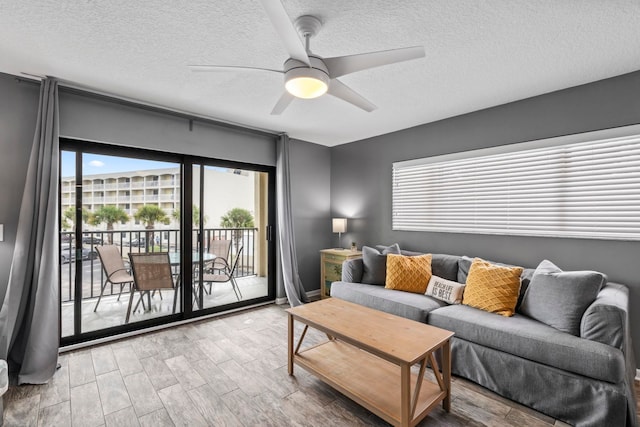 living room with a textured ceiling and ceiling fan