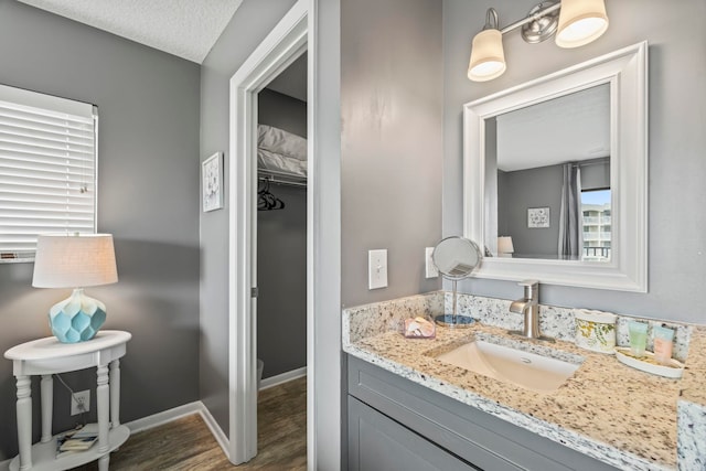 bathroom with a textured ceiling, hardwood / wood-style floors, and vanity