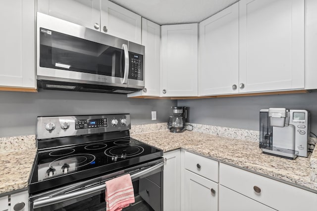 850 A1A Beach Blvd Unit 3, Saint Augustine Beach, FL 32080 - kitchen with appliances with stainless steel finishes, white cabinetry, and light stone counters