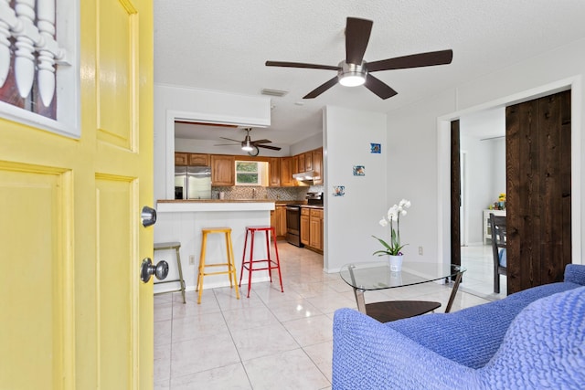 bedroom featuring stainless steel fridge, a textured ceiling, and light tile patterned flooring