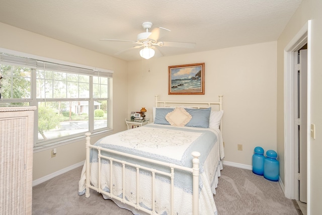 carpeted bedroom featuring a textured ceiling and ceiling fan