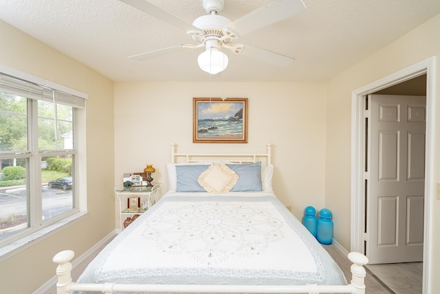 bedroom with a textured ceiling and ceiling fan