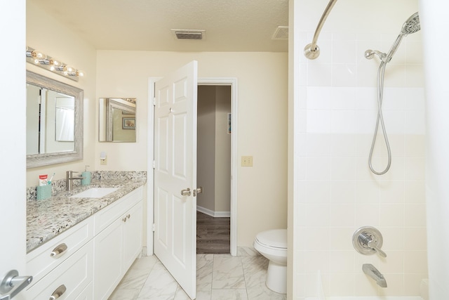 full bathroom with vanity, tiled shower / bath, and toilet