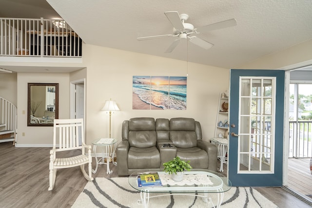 living room featuring ceiling fan, vaulted ceiling, hardwood / wood-style floors, and a textured ceiling