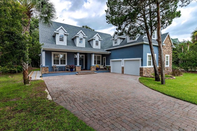 view of front of home with a porch, a garage, and a front yard