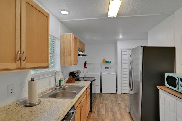 237 Riberia St, Saint Augustine, FL 32084 - kitchen with appliances with stainless steel finishes, a sink, light wood-style floors, separate washer and dryer, and under cabinet range hood
