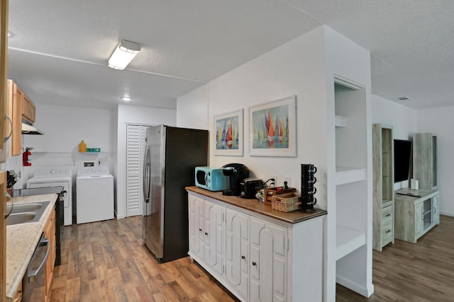 237 Riberia St, Saint Augustine, FL 32084 - kitchen with a textured ceiling, appliances with stainless steel finishes, washing machine and dryer, and light wood finished floors