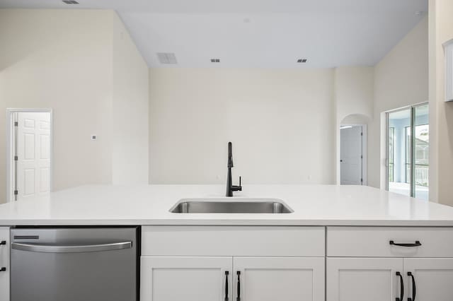 kitchen featuring stainless steel dishwasher, white cabinetry, and sink