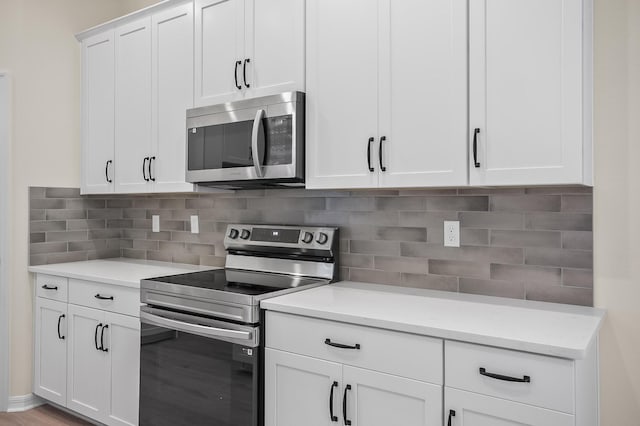 kitchen featuring stainless steel appliances, light stone counters, light hardwood / wood-style flooring, backsplash, and white cabinets