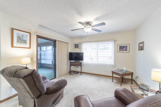 carpeted living room featuring ceiling fan and a textured ceiling