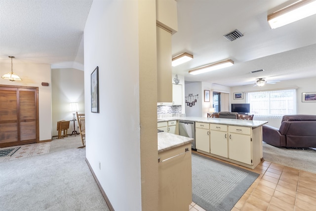 kitchen with stainless steel dishwasher, kitchen peninsula, light carpet, and pendant lighting