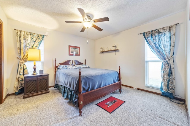 carpeted bedroom with ceiling fan and a textured ceiling