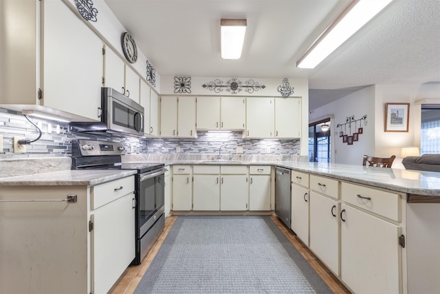 kitchen with white cabinets, kitchen peninsula, sink, and stainless steel appliances