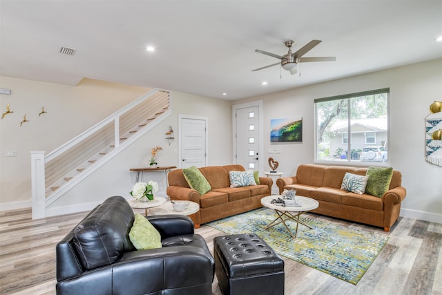 living room featuring recessed lighting, visible vents, baseboards, stairs, and light wood-style floors