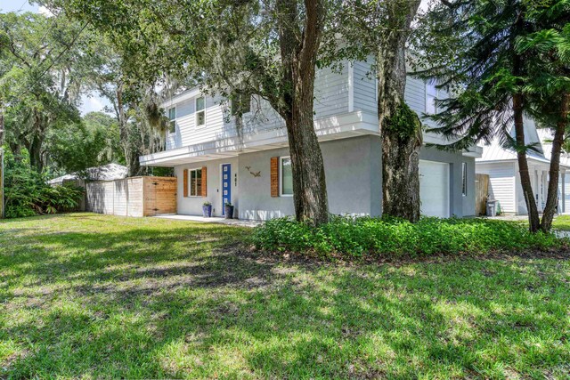 401 B St, Saint Augustine, FL 32080 - view of front facade featuring a garage, fence, a front yard, and stucco siding