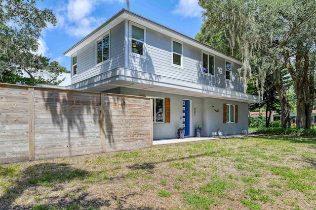 exterior space with fence, a lawn, and a patio