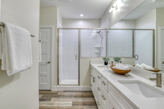 bathroom featuring wood-type flooring, vanity, and a shower with door