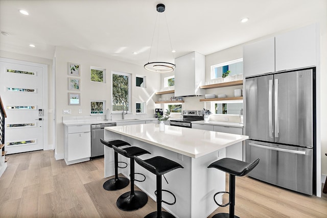 kitchen featuring pendant lighting, a center island, white cabinetry, and appliances with stainless steel finishes