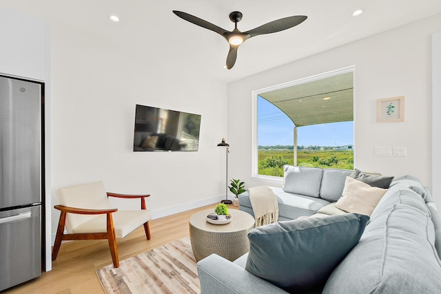 living room featuring ceiling fan and light hardwood / wood-style flooring